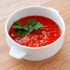 Tomato-lentil soup, decorated with herbs. Ingredients: tomatoes in their own juice, lentils, onions, spices. Square format.