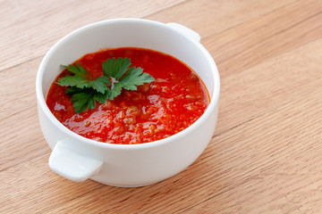Tomato-lentil soup, decorated with herbs. Ingredients: tomatoes in their own juice, lentils, onions, spices.