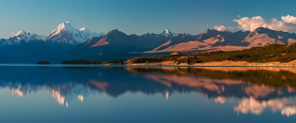 Snowy mountain range reflected in the still water of Lake Pukaki, Mount Cook, South Island, New...