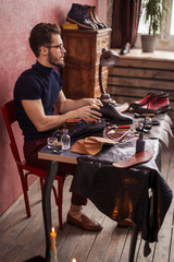 talented shoemaker giving a lovely shine to shoes, side view photo