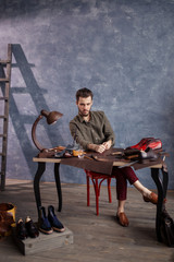serious shoemaker thinking about business problems.full length photo