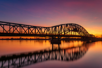 Fototapeta na wymiar iron truss bridge at sunset