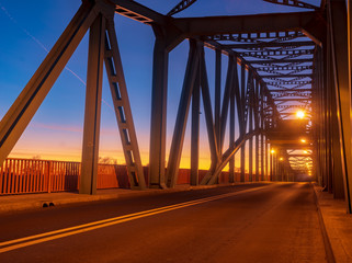 Fototapeta na wymiar iron truss bridge at sunset