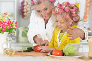 Portrait of senior woman and granddaughter at kitchen