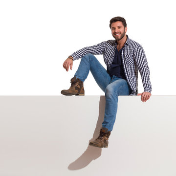 Happy Hendsome Man Is Sitting Relaxed On A Top