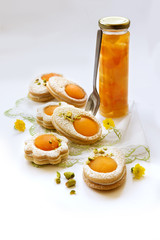Cookies in the shape of white eggs with apricot yolk with pistachios as homemade decoration
