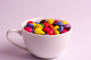 Multi-colored dragee in a white cup