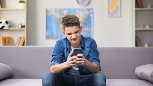 Anxious male teenager losing money in online casino, lack of parental control