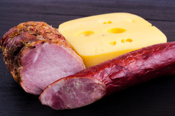 Homemade meat, sausage and cheese on a dark background