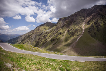 Pass road in Switzerland in summer. Sunny weather with a few clouds.