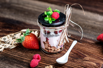 Delicious home-made muesli with yoghurt and fresh berries, beautifully presented in a mason jar to take away on the go