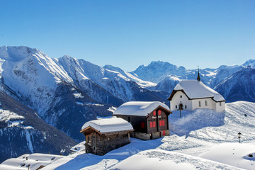 Chapel Maria in Snow (Kapelle zum Schnee) with two old chalets - the landmark architecture in the...