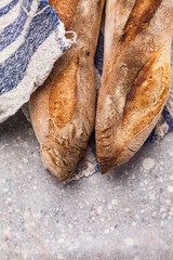 Two wheat Sourdough Baguettes on a linen napkin. Detail of two homemade artisanal bread.