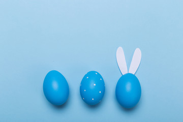 Blue easter eggs in nest on pastel color background with space.
