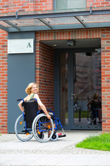 woman on wheelchair entering the building