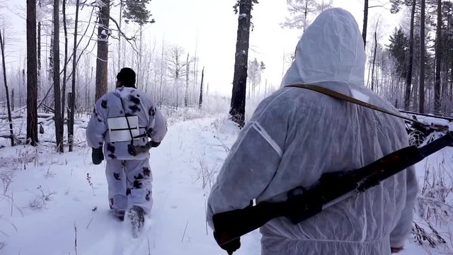 Two Hunters in the Woods. Armed Rangers in winter forest