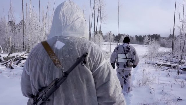 Two Hunters in the Woods. Armed Rangers in winter forest