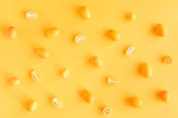 A slices of fresh juicy yellow Kumquats. Texture summer bright background, pastel pattern.