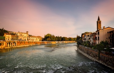 Obraz premium Verona cityscape during late sunset with Adige river and Church Complesso della Cattedrale-Duomo. Verona is located in Veneto, Italy,