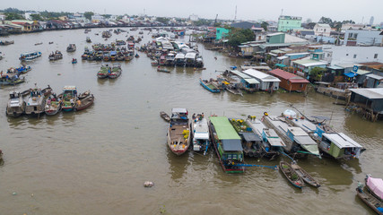 Aerial view, top view Cai Rang floating market. Tourists, people buy and sell food, vegetable, fruits on boat, ship at river market. Traditional popular method of buying and selling on river market