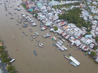 Aerial view, top view Cai Rang floating market. Tourists, people buy and sell food, vegetable, fruits on boat, ship at river market. Traditional popular method of buying and selling on river market