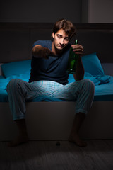 Man drinking in the bed under stress