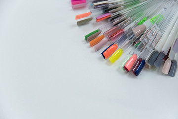 Nail polish swatches in different fashion color lacquer in tips. Multicolor nail polish palette for client's choice. Nail art design wheel. Set of false nails for manicure in beauty salon.