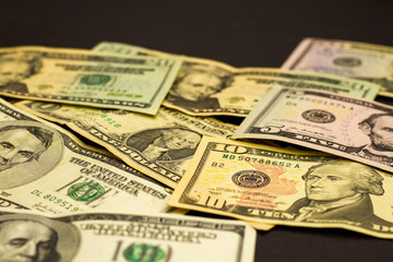 Easy money dollar bills on a dark background. Crumpled US dollars lie on a dark table. The concept of easy money.