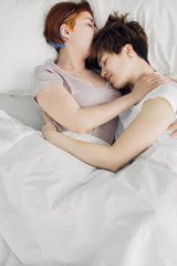 two lesbian girls sleeping on the bed in the modern bedroom. top view photo.lesbian vice