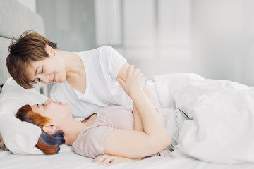 two young women lying in a white bedroom. close up photo.love, relation