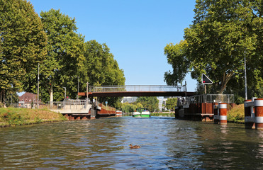 Fototapeta na wymiar barge on a river passing under a lift bridge
