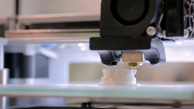 Close up shot - 3D printer prints physical 3D model with plastic wire filament at modern technology exhibition. Additive technologies, science and futuristic concept