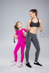 Beautiful woman and her daughter with jumping rope