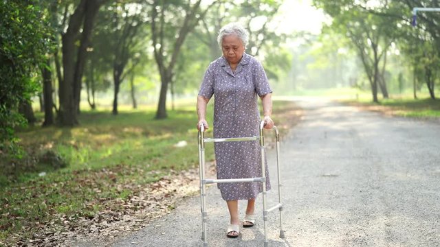 Asian senior or elderly old lady woman patient walk with walker in park : healthy strong medical concept 