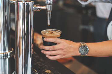 nitro coffee in cup with soft-focus and over light in the background - obrazy, fototapety, plakaty