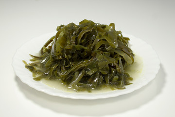 Sea kale, seafood, cut into strips. Laid out on a white bowl photographed on a light background.