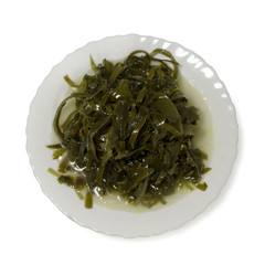 Sea kale, seafood, cut into strips. Laid out on a white plate. Isolated on white background.