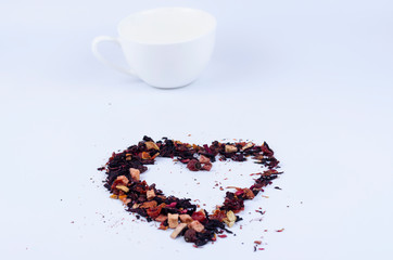 Obraz na płótnie Canvas Hearts-shaped tea with fruit elements. White cup on a light background