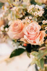 Pink Roses bouquet in a vase on a wooden table. Florist
