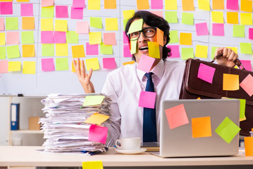 Young employee in conflicting priorities concept 
