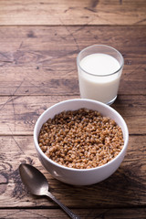 Buckwheat porridge with milk on a wooden table