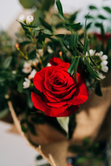 Detail of a Red Roses bouquet on a wooden table. Floristflorist