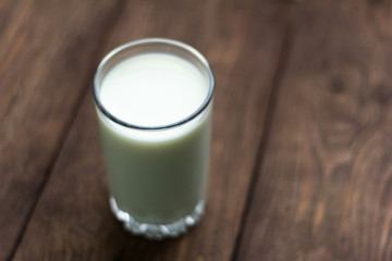 glass of fresh cow's milk on wooden background