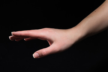 Young woman hand isolated on black background