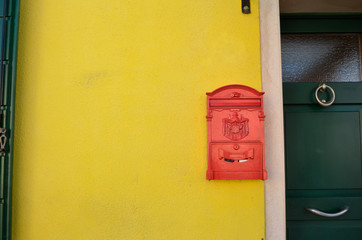 Post box on colorful yellow wall. Burano island near Venice, Italy