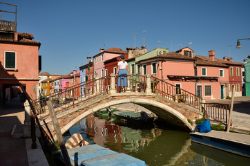 Fototapeta na wymiar Woman tourist. Colorful concept. Venice, Burano island canal, small colored houses and the boats.