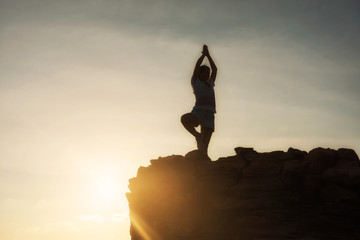 Yoga at mountain summit during sunset