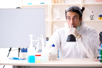 Young handsome chemist working in the lab 