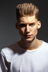 Male beauty concept. Portrait of a fashionable young man with stylish haircut. Close up. Copy-space