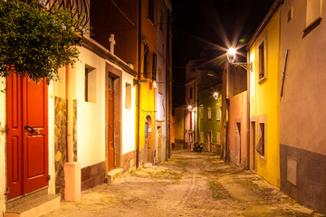 Fototapeta na wymiar Narrow ancient streets during the evening in the little medieval town Bosa, Sardinia Island, Italy